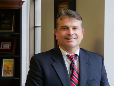 Headshot of Dr. Lezama standing next to a window